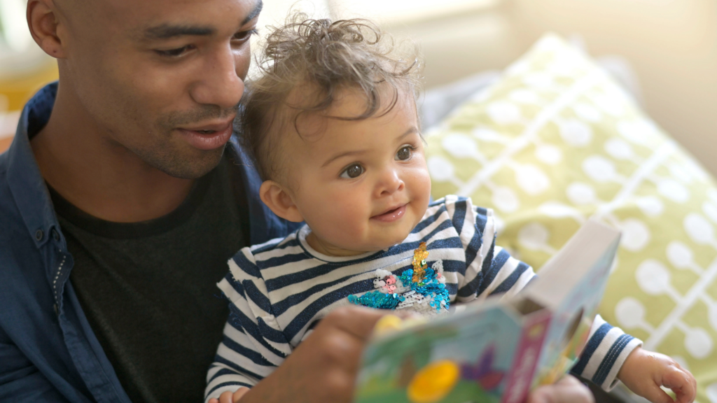 baby reading book with parent