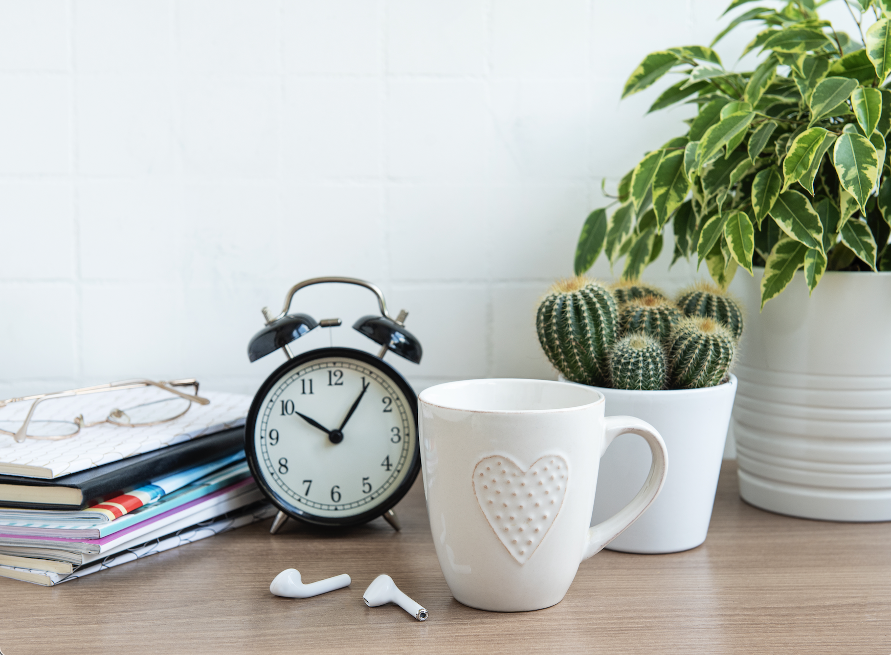 A clock ticking on a desk with writing